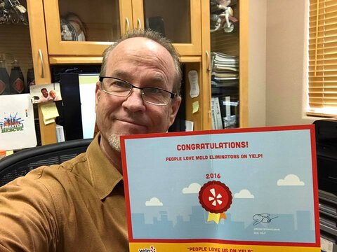 owner of mold eliminators holding award for best water damage restoration in las vegas